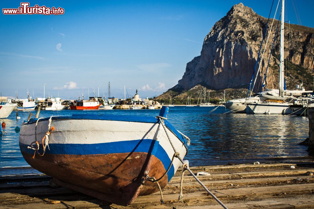 Immagine Una barca da pesca ormeggiata al porto di San Vito Lo Capo, Sicilia. Sullo sfondo, Monte Monaco, il massiccio roccioso che deve il suo nome alla forma che ricorda un monaco in ginocchio con le mani giunte in preghiera.