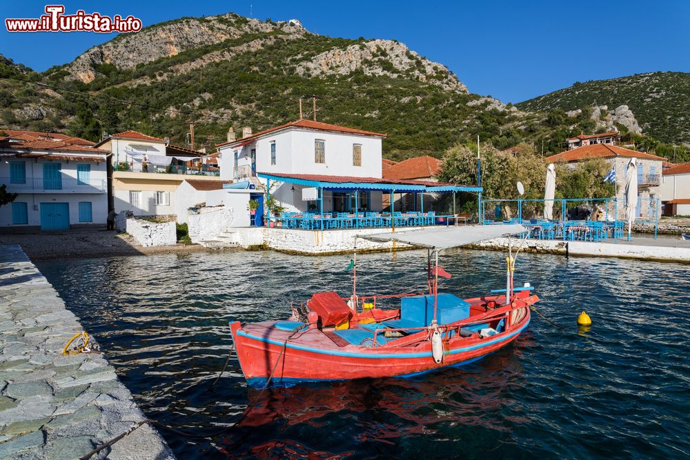 Immagine Una barchetta da pesca con il villaggio di Agia Kyriaki sullo sfondo, Trikeri (Grecia).