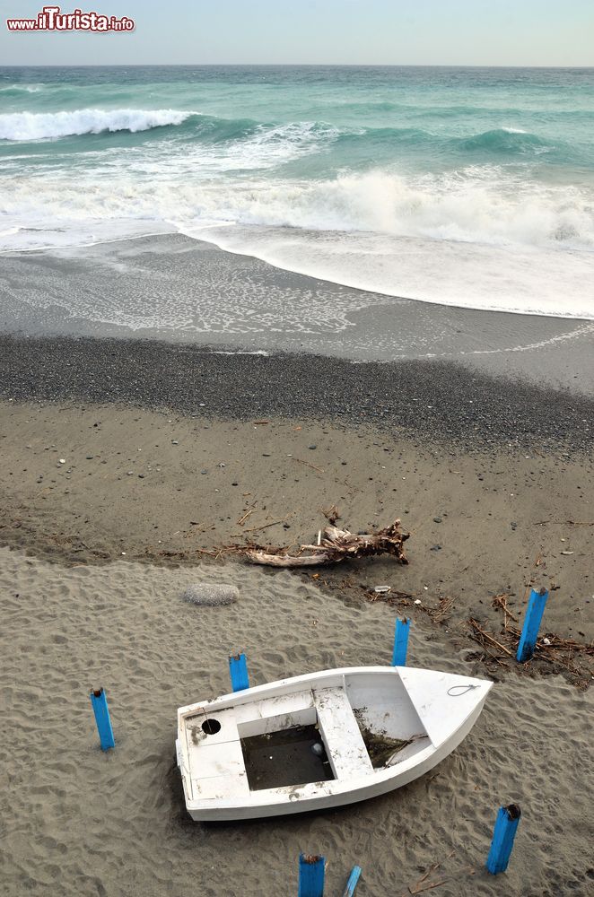 Immagine Una barchetta in legno su una spiaggia di Celle Ligure, Liguria, fotografata dall'alto.