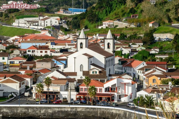 Immagine Una bella veduta dall'alto del villaggio di Lajes, a Pico, isola delle Azzorre dove la montagna da cui prende il nome emerge dal mare e si innalza sino a superare le nuvole: tutt'intorno l'azzurro di cielo e acqua e le macchie verdi delle altre isole su cui incombe la sua imponente mole - © KamilloK / Shutterstock.com