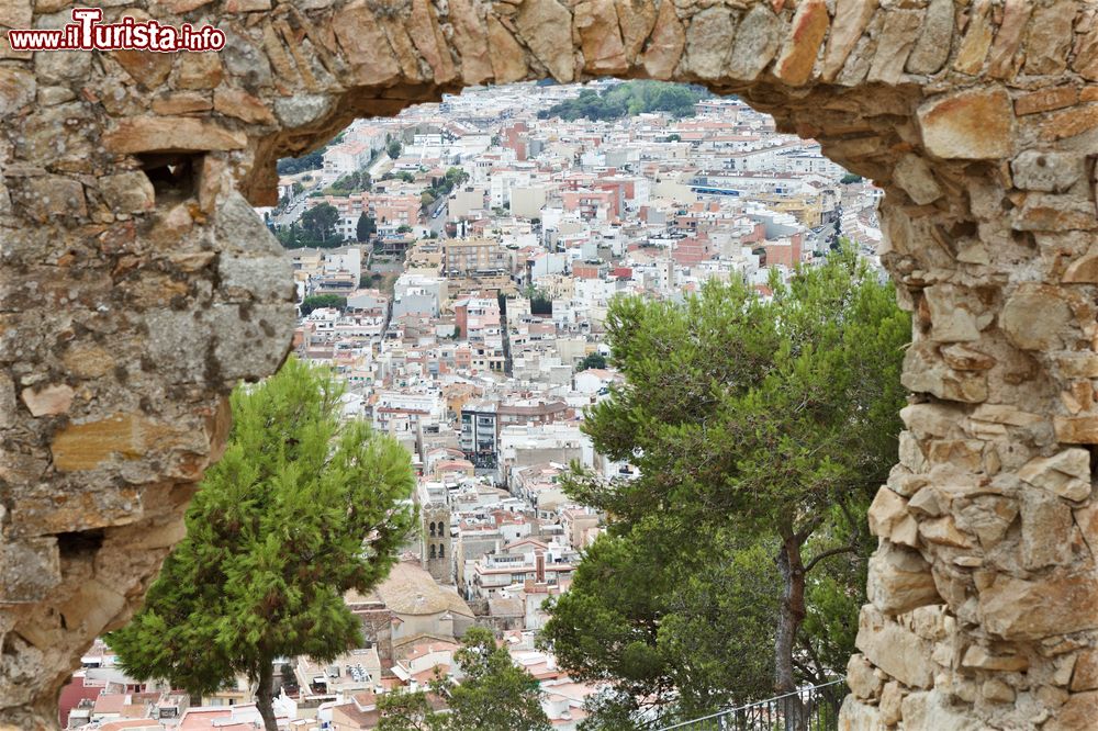 Immagine Una bella veduta della città attraverso un arco in pietra dalle colline a Blanes, Spagna. Il territorio di questo comune si trova vicino alla foce del fiume Tordera.