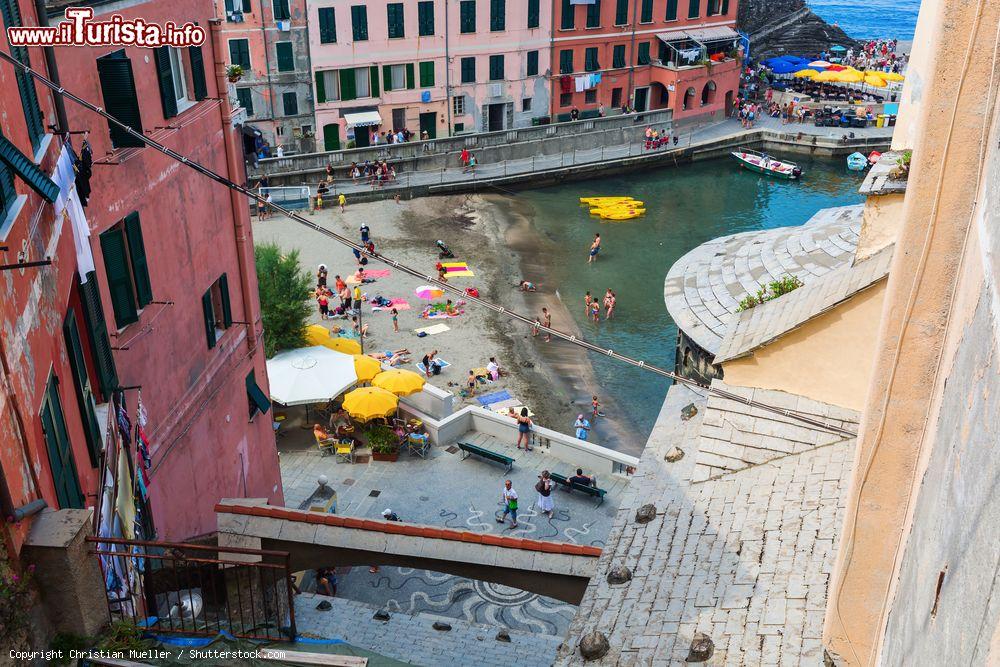 Immagine Una bella veduta di Vernazza con gente al mare e nella piazza, La Spezia, Liguria. Questo pittoresco borgo è uno dei siti protetti dall'Unesco nel Parco Nazionale delle Cinque Terre - © Christian Mueller / Shutterstock.com