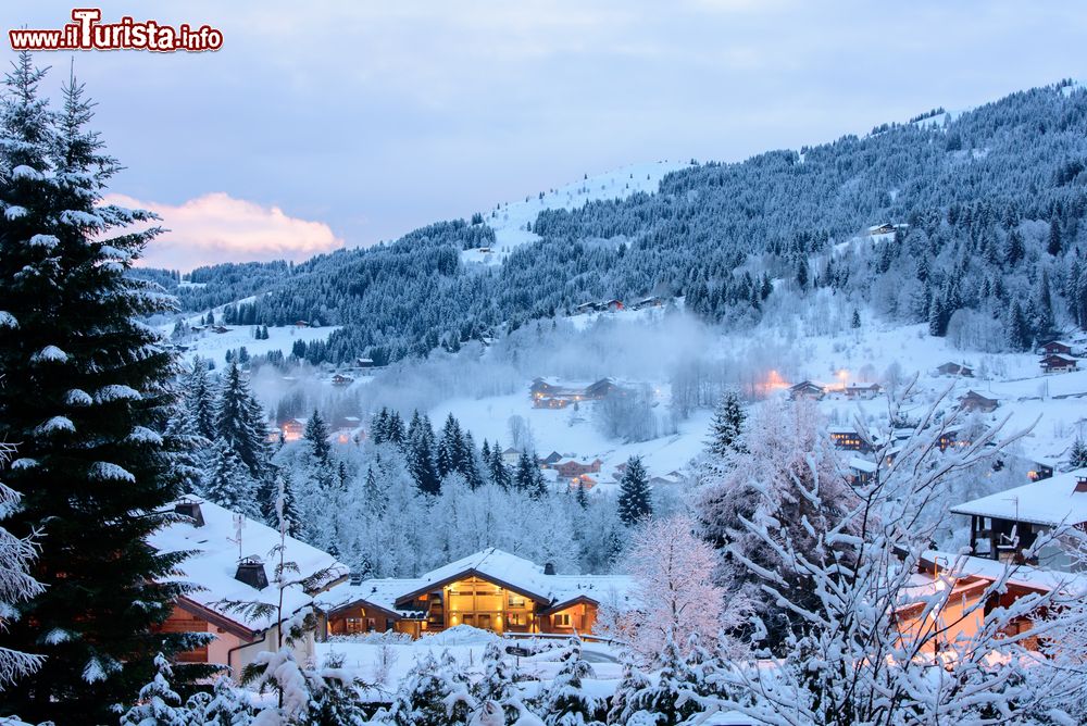 Immagine Una bella veduta invernale della vallata di Les Gets, Francia, di sera. A illuminarla, le luci di baite e case in legno.