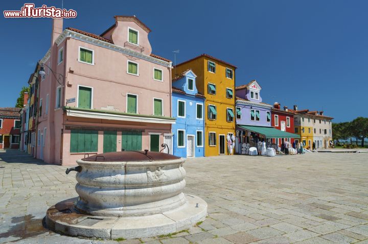 Immagine Una calda giornata di sole a Burano, in Piazza Baldassarre Galuppi - Piazza Baldassarre Galuppi è il cuore di Burano, in quanto è l'unica piazza presente sull'isola, costruita tramite l'interramento di un canale. Questa bella piazza è stata intitolata al personaggio che probabilmente ha dato più lustro a Burano nel corso del tempo: Baldassarre Galuppi, famoso compositore vissuto nel XVIII secolo. - © Lee Yiu Tung / Shutterstock.com
