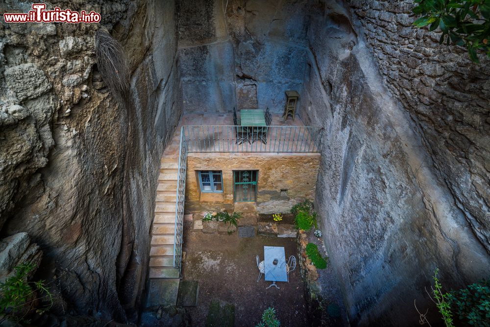 Immagine Una casa costruita nella roccia con tavolo e sedie nella terrazza a Bonnieux, Provenza, Francia.