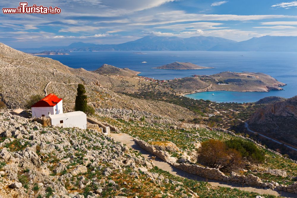Immagine Una chiesa con il tetto rosso sulle colline dell'isola di Chalki, Dodecaneso, Grecia.