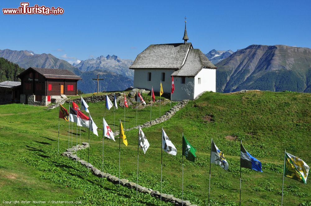 Immagine Una chiesa di Bettmeralp, Svizzera. Suggestivo il percorso allestito con le bandiere per raggiungere l'edificio religioso - © Peter Moulton / Shutterstock.com