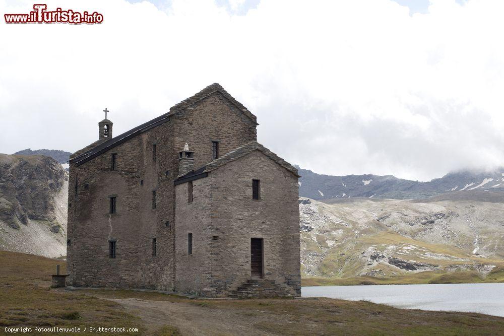 Immagine Una chiesetta di montagna in pietra vicino a un lago a Verres, Valle d'Aosta  - © fotosullenuvole / Shutterstock.com