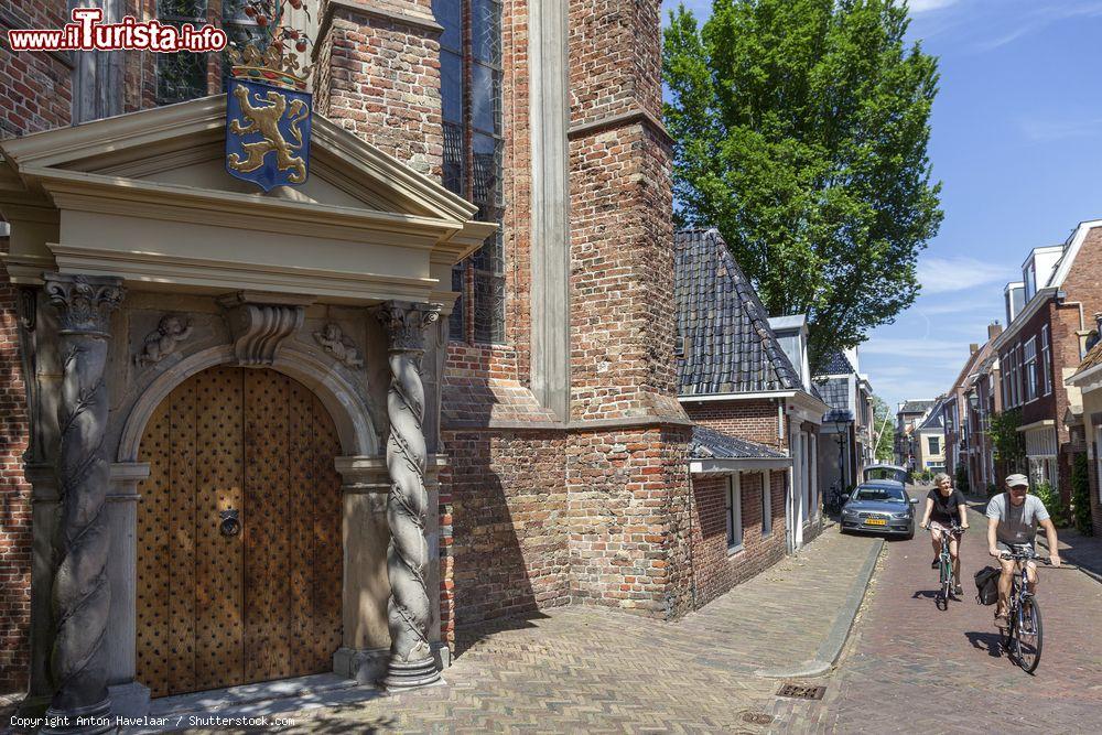 Immagine Una coppia a passeggio in bici lungo le strade di Leeuwarden, Paesi Bassi. Sulla sinsitra, il bel portale d'ingresso della chiesa giacobina - © Anton Havelaar / Shutterstock.com