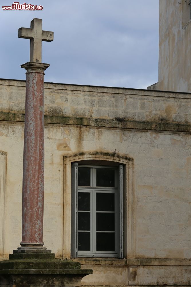 Immagine Una croce in pietra su una colonna davanti a una casa a Montpellier, Francia.
