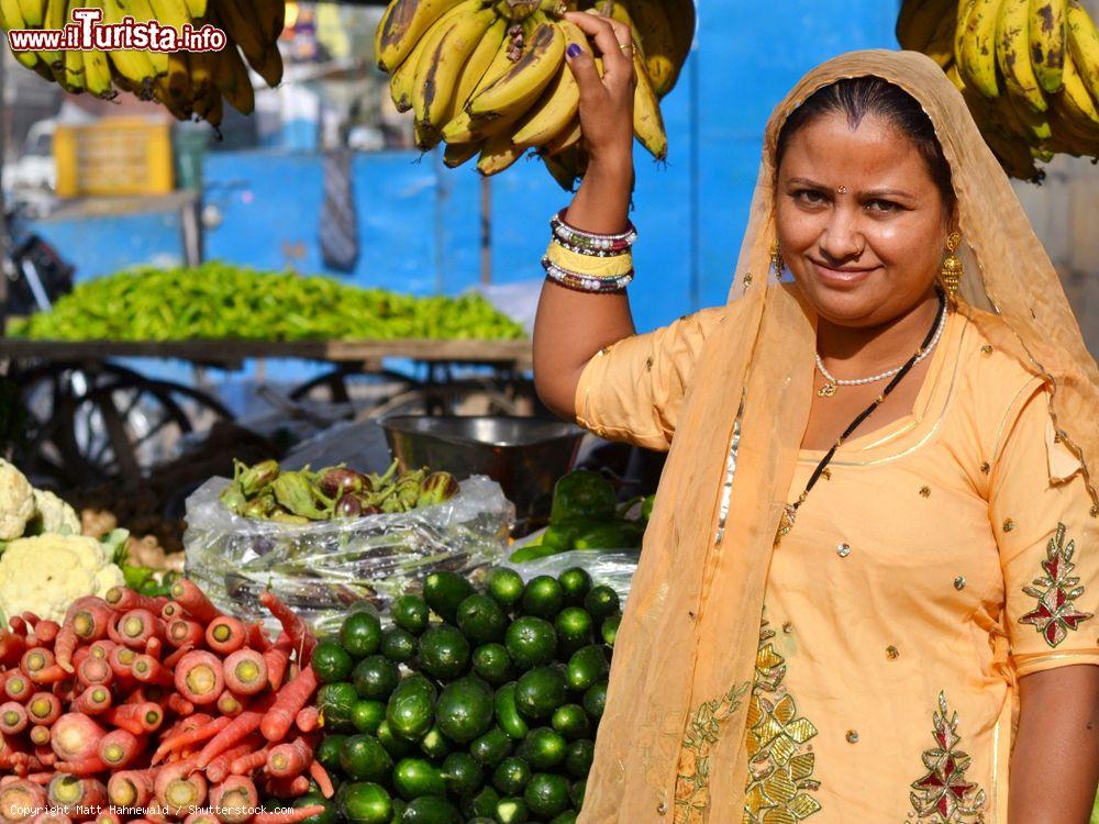 Immagine Una donna al mercato di Jaisalmer vende frutta e verdura, Rajasthan, India. L'abito indossato è un tipico sari indiano - © Matt Hahnewald / Shutterstock.com