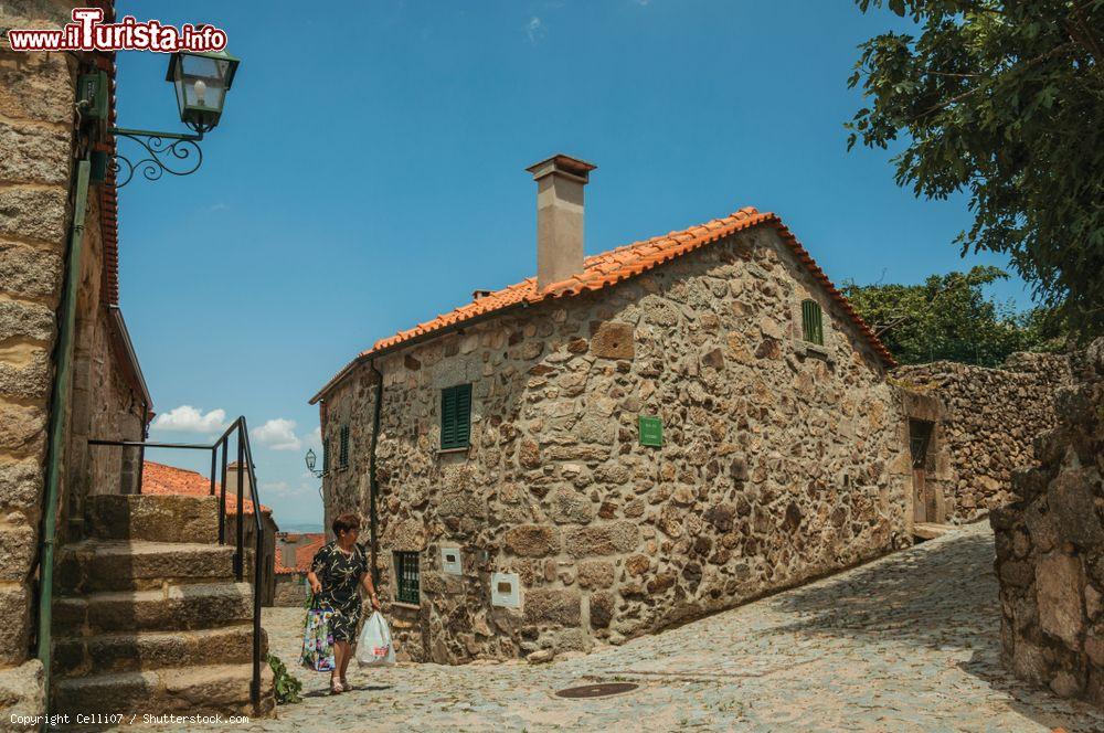 Immagine Una donna con le borse della spesa in un vicolo di Linhares da Beira, Portogallo - © Celli07 / Shutterstock.com