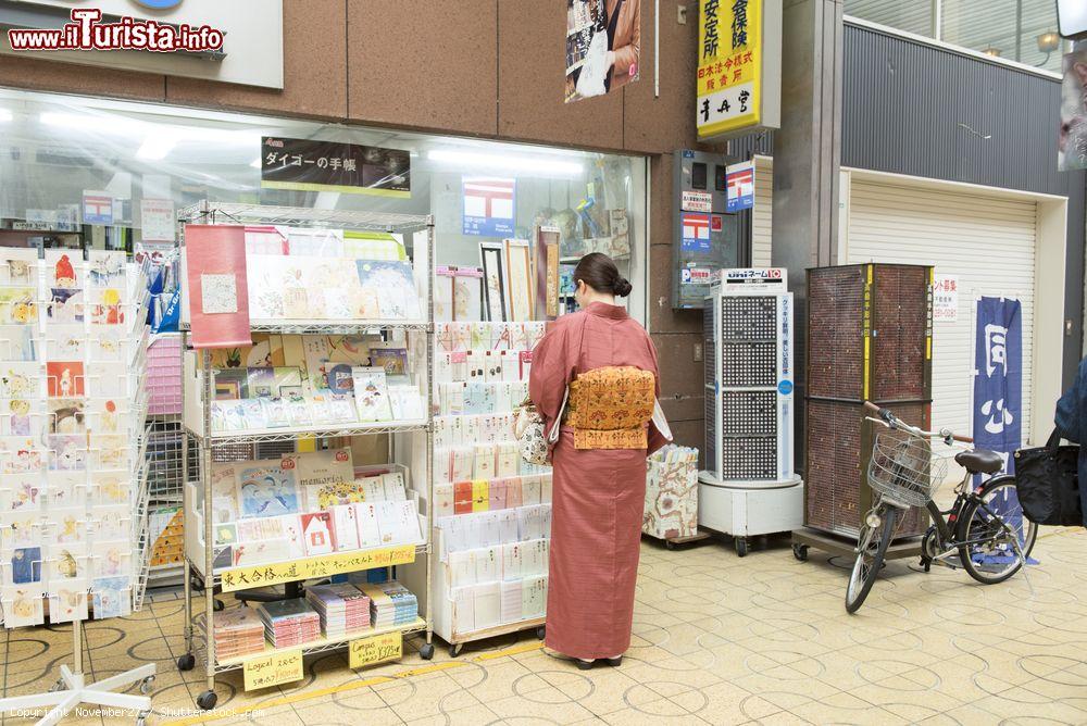 Immagine Una donna con un kimono tradizionale davanti ad un negozio a Himeji in Giappone - © November27 / Shutterstock.com