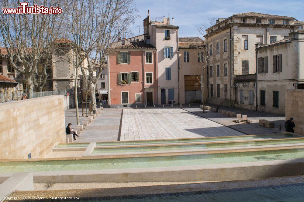 Immagine Una donna legge un libro seduta vicino alle fontane in Place du Chapitre a Nimes, Francia - © Travelsewhere / Shutterstock.com