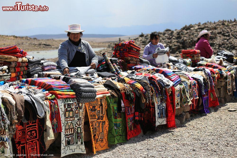 Immagine Una donna peruviana vende abiti colorati in alpaca in un tipico mercato per turisti vicino a Arequipa, Perù - © padchas / Shutterstock.com