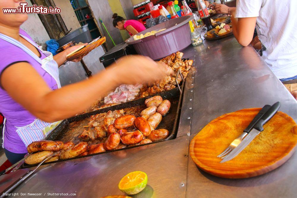 Immagine Una donna prepara della carne per l'asado in un locale di Asuncion, Paraguay - © Don Mammoser / Shutterstock.com
