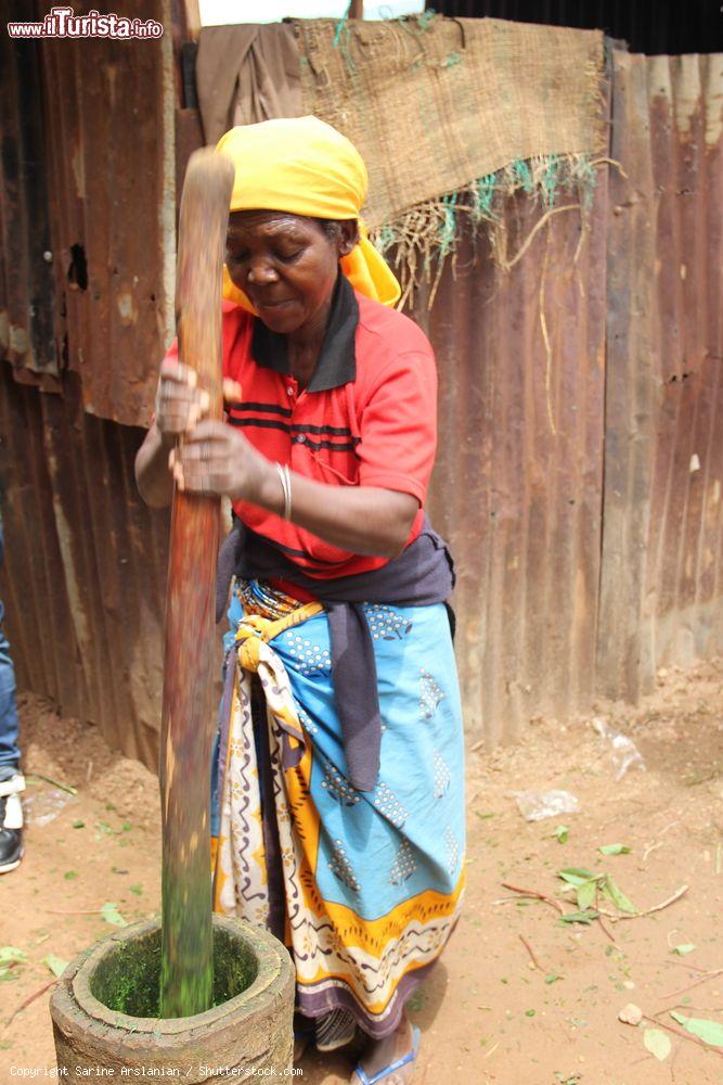 Immagine Una donna ruandese a Nyamirambo (Kigali) lavora foglie di manioca per cucinare il famoso piatto regionale noto come "isombe" - © Sarine Arslanian / Shutterstock.com