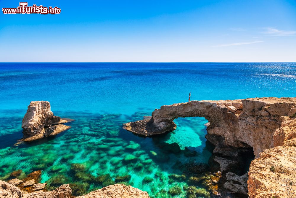 Immagine Una donna su uno spettacolare arco di roccia vicino a Ayia Napa, Cape Greco, isola di Cipro. Questo luogo è considerato il ponte degli innamorati.