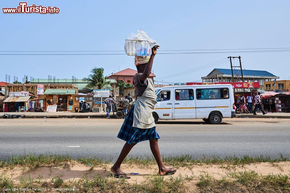 Immagine Una donna vende acqua passeggiando lungo una strada della città di Accra, Ghana - © Danilo Marocchi / Shutterstock.com