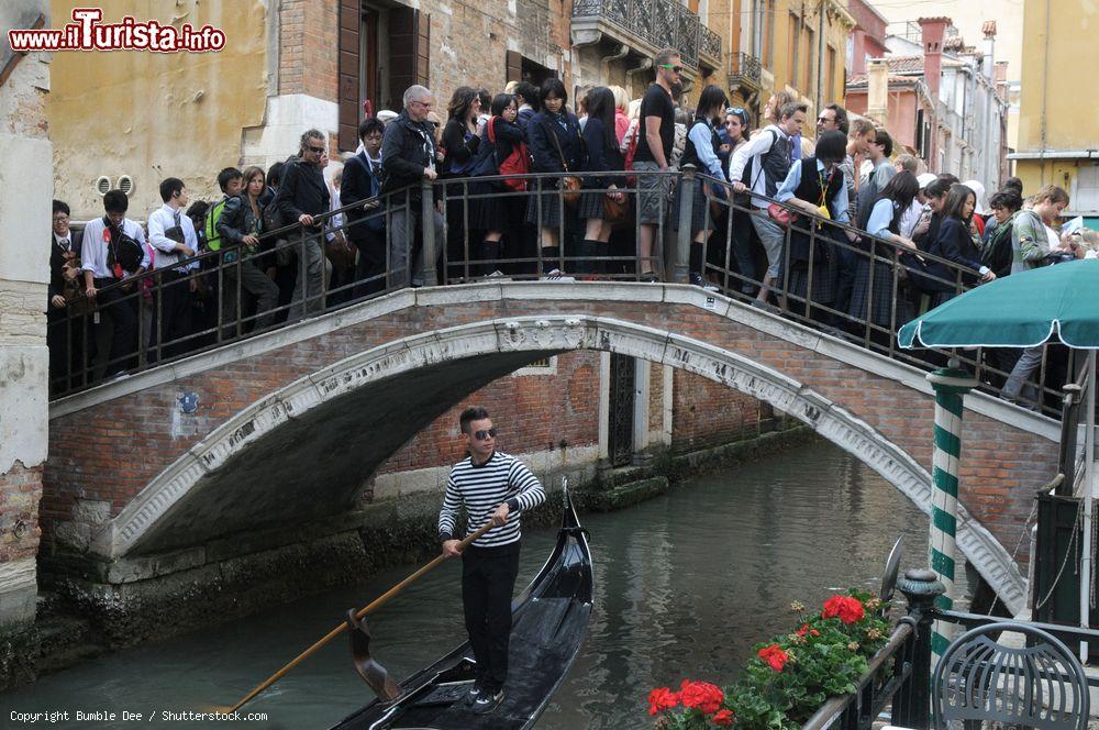 Immagine Una fila di turisti su un ponte di Venezia in una giornata da bollino nero- © Bumble Dee / Shutterstock.com