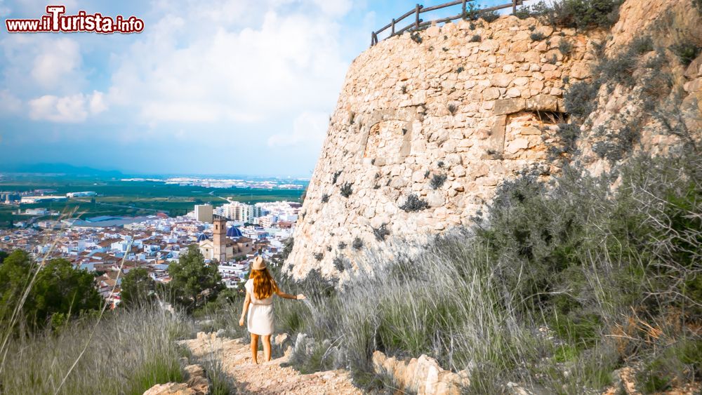 Immagine Una giovane donna passeggia fra le rovine del castello di Santa Anna a Oliva, Spagna.