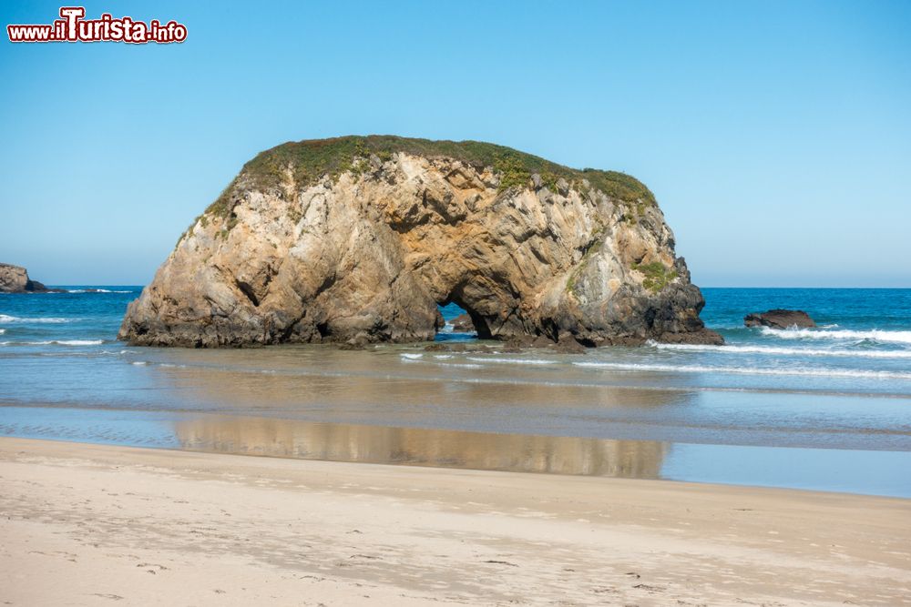 Immagine Una grande  roccia a riva rende unica  Playa Penarronda a Castropol in Spagna