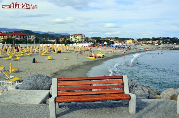 Immagine Una panchina sul molo di Albissola Marina con la spiaggia sullo sfondo, Savona, Liguria - © maudanros / Shutterstock.com