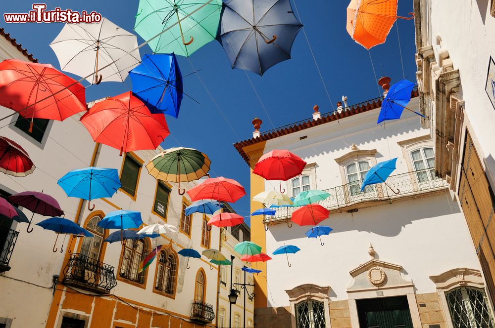 Immagine Una piazza di Evora colorata da mille ombrelli, Portogallo.