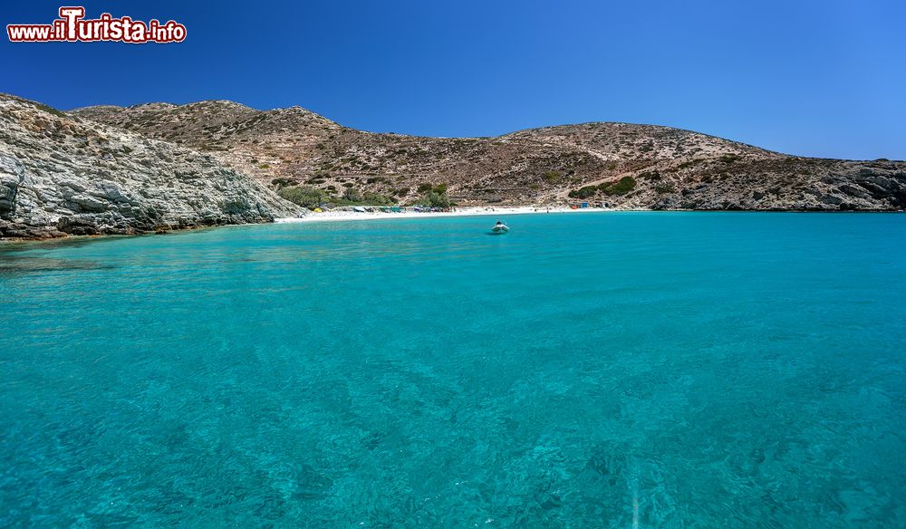 Immagine Una piccola spiaggia di sabbia lambita dalle acque dell'Egeo, isola di Donoussa, Grecia. Sullo sfondo una barca ormeggiata.