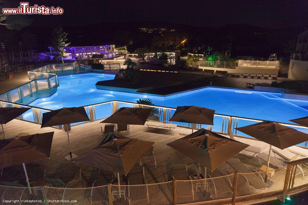 Immagine Una piscina deserta con ombrelloni fotografata di notte a Ramatuelle, Francia - © riekephotos / Shutterstock.com