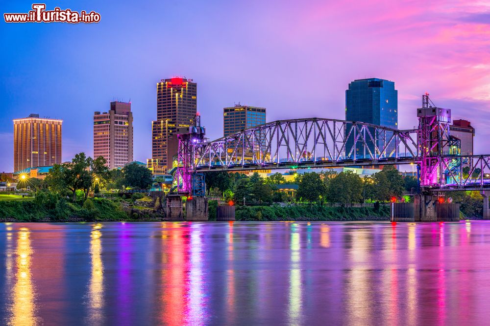 Immagine Una pittoresca skyline della città di Little Rock lungo il fiume Arkansas (USA): al crepuscolo le luci di palazzi e strutture si riflettono nell'acqua.