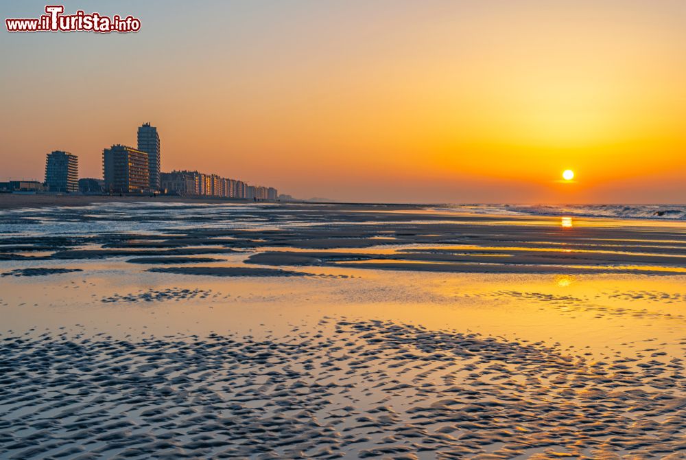 Immagine Una pittoresca veduta della spiaggia di Ostenda al tramonto, Belgio: affacciata sul Mare del Nord, questa località è fra le più apprezzate del paese. Sullo sfondo, la skyline della città con grattacieli e appartamenti.