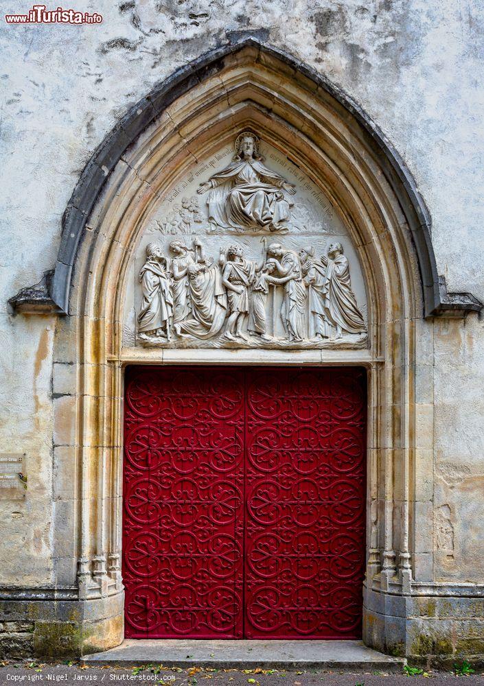 Immagine Una porta rossa con decorazioni scultoree nella chiesa di Sant'Orso a Montbard, Borgogna (Francia) - © Nigel Jarvis / Shutterstock.com