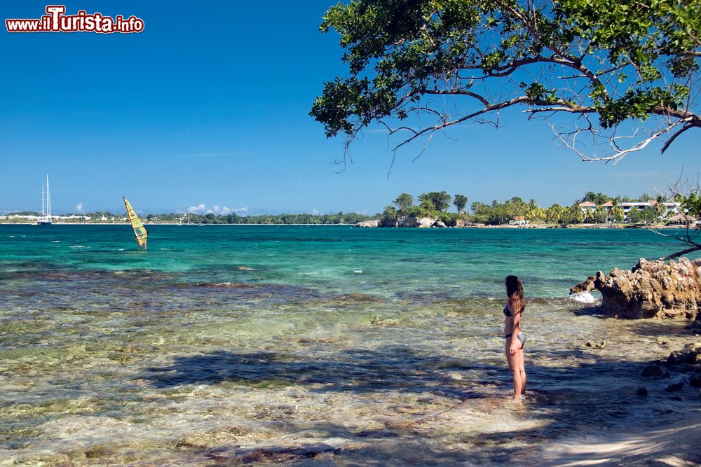 Immagine Una ragazza sulla spiaggia osserva il mare dei Caraibi, Giamaica. Questa terra offre lunghe spiagge, insenature protette, montagne scoscese, cascate, caverne e tante giornate di sole.