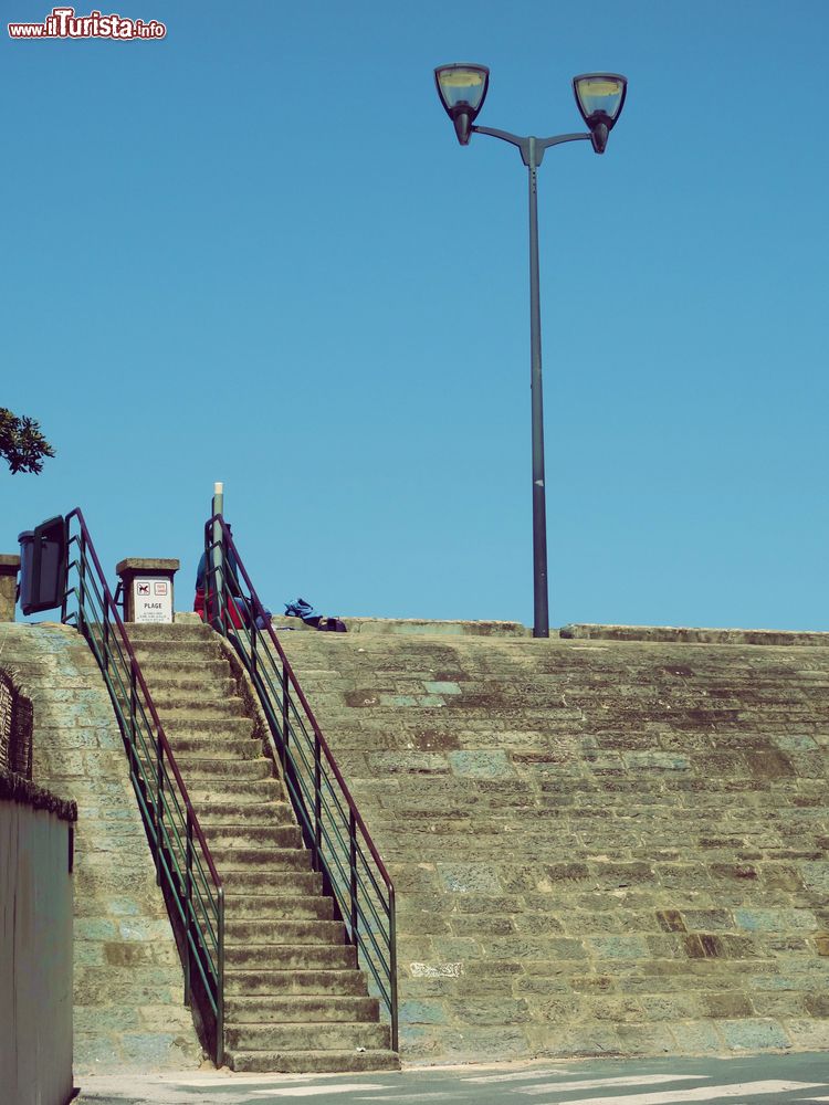 Immagine Una scalinata che porta alla spiaggia di Saint-Jean-de-Luz, Francia. Da un lato, una lampada in ferro battuto.