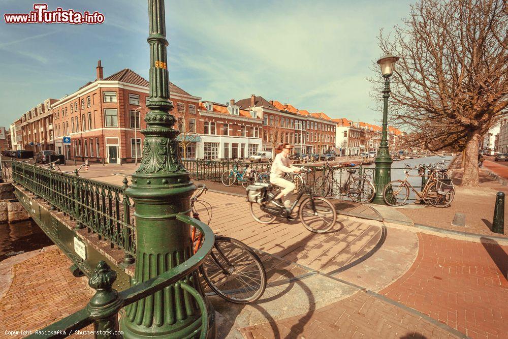 Immagine Una signora percorre in bicicletta un ponte a L'Aia, Olanda - © Radiokafka / Shutterstock.com