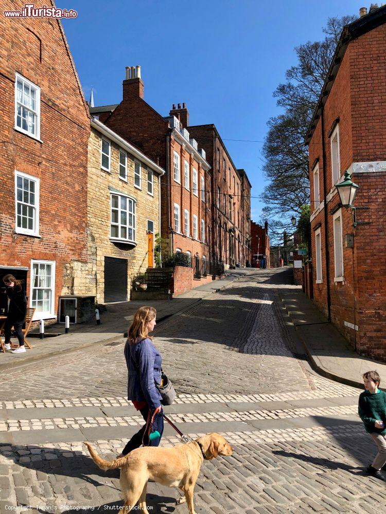 Immagine Una signora porta a passeggio il cane nel centro di Lincoln, Inghilterra - © Imran's Photography / Shutterstock.com