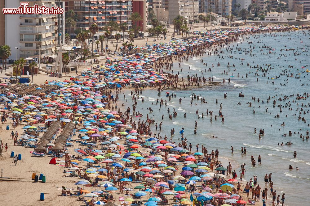 Immagine Una spiaggia affollata in estate a Calpe, Spagna. La città si affaccia sul Mar Mediterraneo.