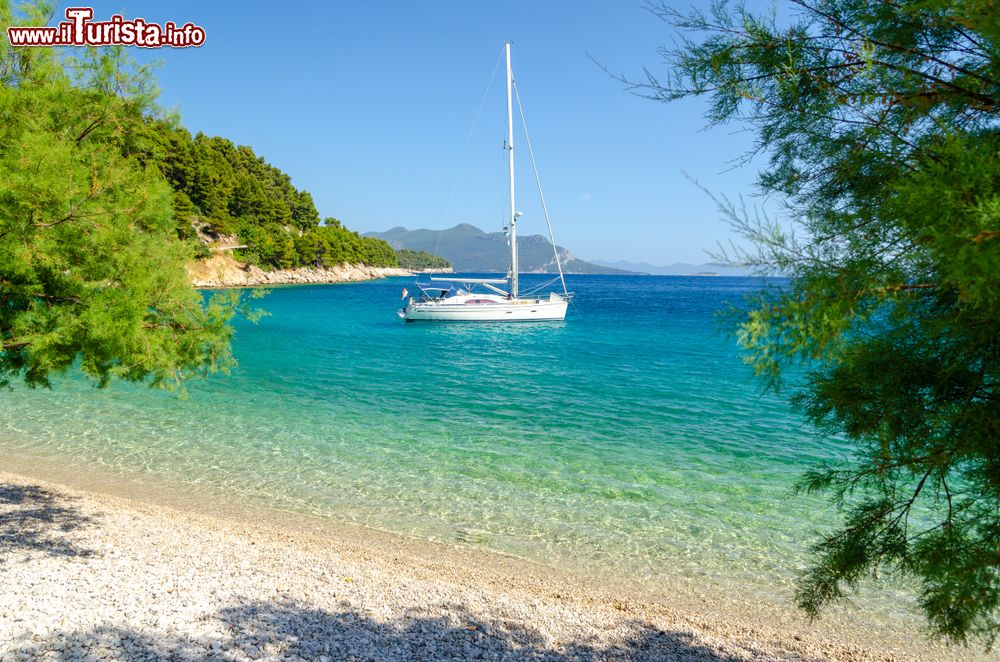 Immagine Una spiaggia da sogno nella penisola di Peljesac vicino a Trstenik (Croazia). Sullo sfondo, un'imbarcazione ormeggaita al largo della costa.
