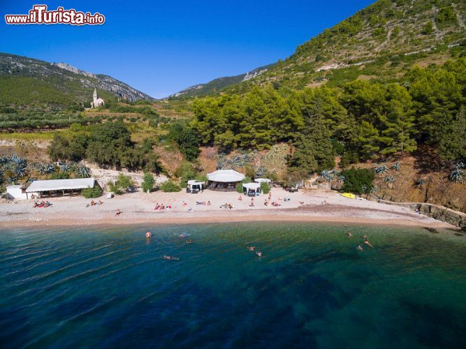 Immagine Una spiaggia dell'isola di Vis, Croazia, con turisti in relax. La natura ancora selvaggia e il mare dalle mille tonalità del blu e dell'azzurro ne fanno una delle destinazioni preferite da chi si reca in Croazia nei mesi estivi- © paul prescott / Shutterstock.com