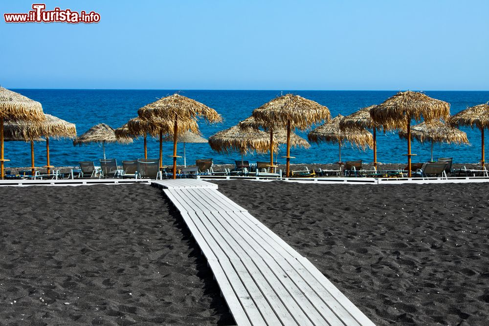 Immagine Una spiaggia nera a Santorini, isole Cicladi, Grecia. Ciottoli finissimi e sabbia nera caratterizzano questo tratto di litorale dell'isola di Santorini che vanta spiagge uniche e diverse fra di loro.