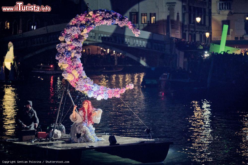 Immagine Una splendida danzatrice su una barca al carnevale di Venezia 2019 (Veneto). La piccola imbarcazione è impreziosita da una composizione floreale - © Gentian Polovina / Shutterstock.com