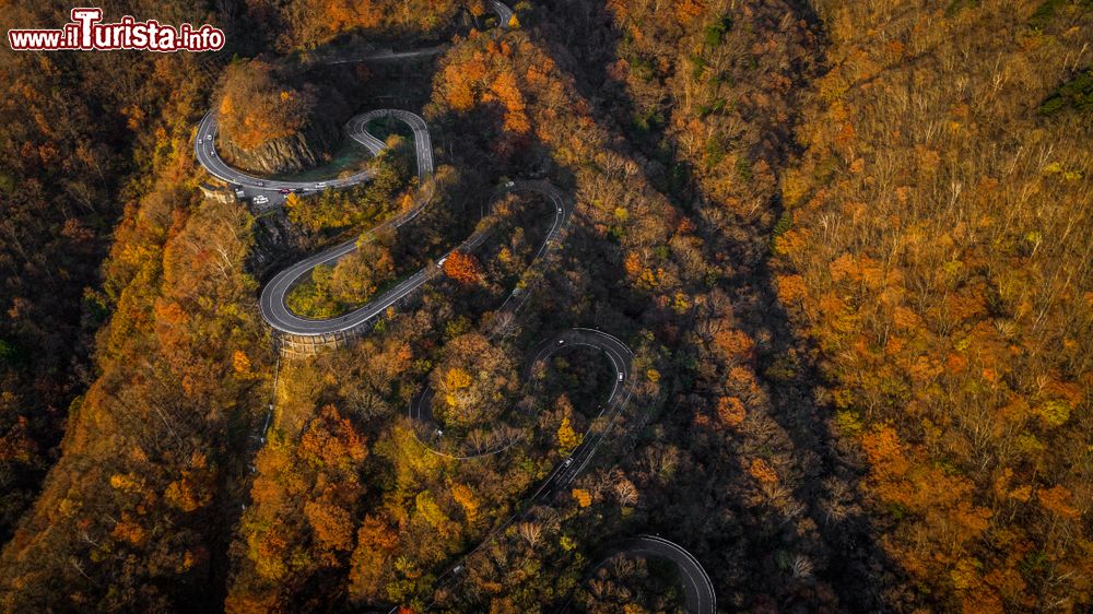 Immagine Una splendida veduta dall'alto con il drone di Irohazaki road, Nikko, Giappone. Si tratta di una strada tortuosa di 48 tornanti che collega il centro di Nikko con le alte quote della regione montuosa di Okunikko. In quest'immagine, il panorama è reso ancora più suggestivo dal foliage autunnale.