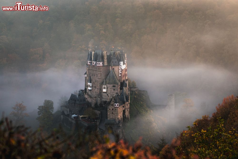 Immagine Una splendida veduta dall'alto del castello di Eltz, Wierschem, in autunno con la nebbia. Situato su una rupe rocciosa alta 70 metri, il castello è circondato sui tre lati dall'Elzbach, un tributario della Mosella sul lato nord.