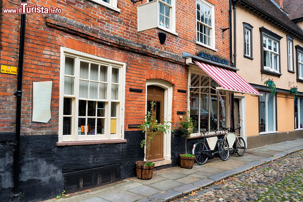 Immagine Una strada ciottolata con negozi nel centro del villaggio di Norwich, Norfolk, Inghilterra.