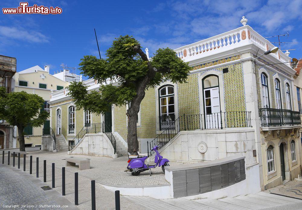 Immagine Una strada del centro di Sesimbra (Portogallo) con un edificio storico in stile moresco e una Vespa - foto © jorisvo / Shutterstock.com