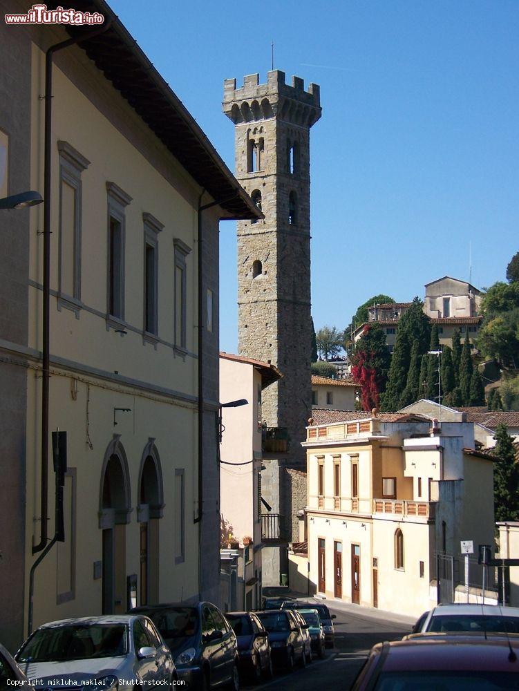 Immagine Una strada di Fiesole con la torre della cattedrale di San Romolo, Toscana. In stile romanico, l'alto campanile si innalza per 42,30 metri alla sinistra della chiesa. In cima è coronato da merli guelfi - © mikluha_maklai / Shutterstock.com