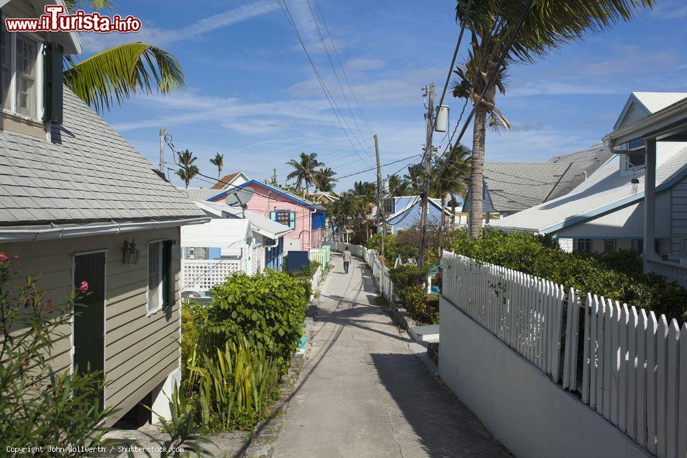 Immagine Un uomo a passeggio per una stradina a Hopetown, a Elbow Cay, Bahamas. Qui le tipiche casette in legno sono immerse nella natura - © John Wollwerth / Shutterstock.com