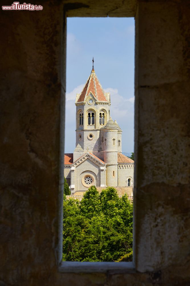 Immagine Una suggestiva vista panoramica dell'abbazia di Lerino, isola di Saint Honorat, Francia. Attraverso la feritoia di un muro in pietra, si può ammirare la torre della chiesa.