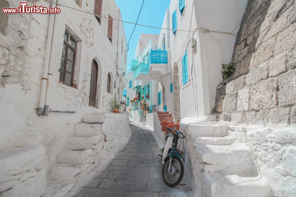 Immagine Una tipica stradina sull'isola di Nisyros, Grecia. Le case intonacate di bianco sono impreziosite da particolari color azzurro.